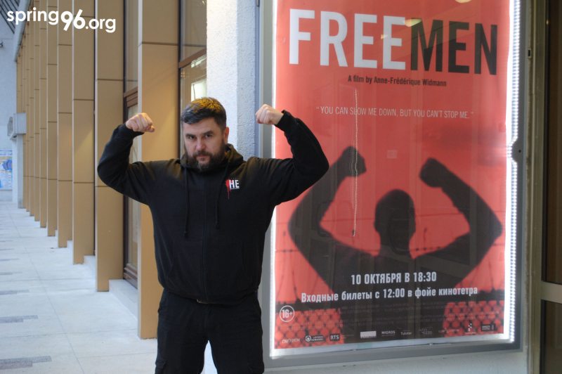 Андрей Полуда на фоне афиши фильма "Свободные люди"