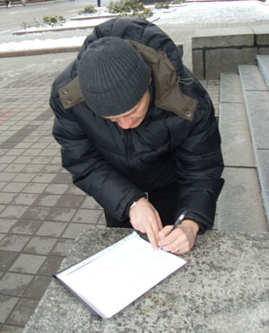 Aleh Volchak while signing the petition