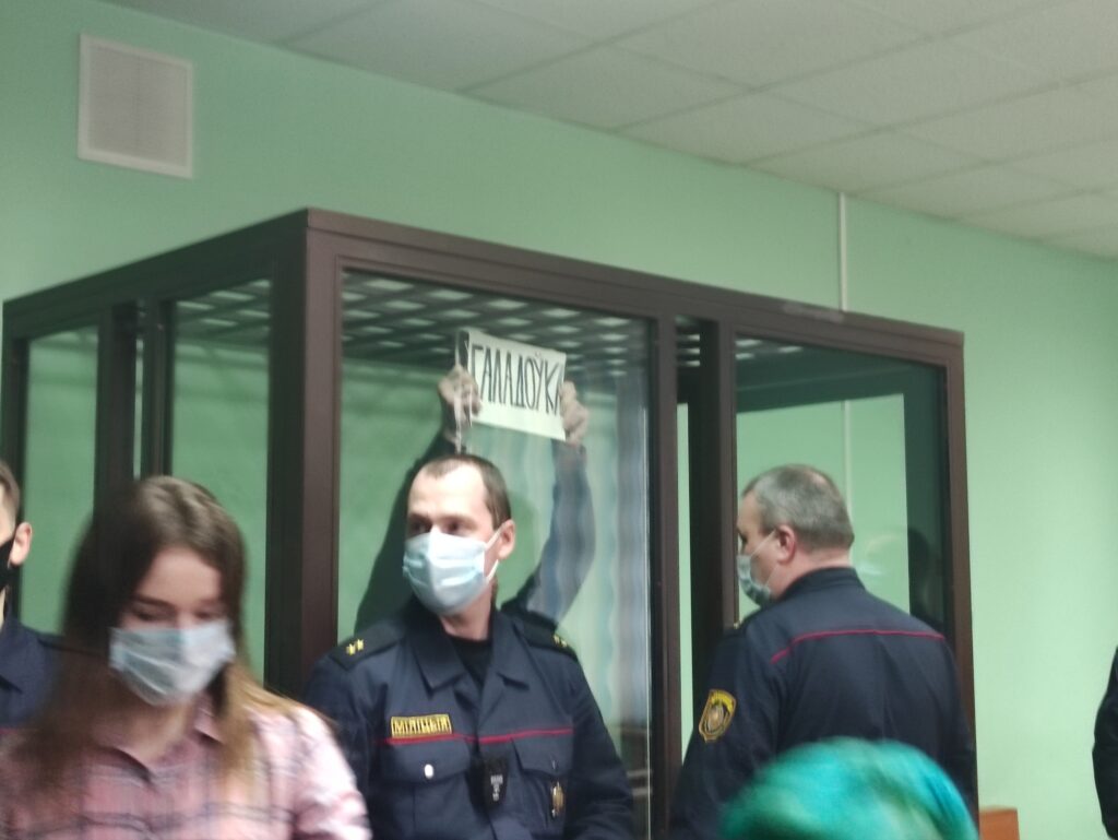 Ihar Bantsar holding a sign reading "Hunger Strike" while on trial at the Lieninski District Court of Hrodna