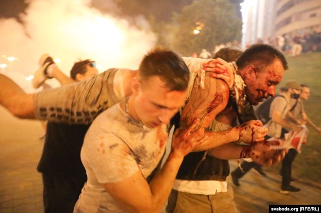Люди несут протестующего, раненого светошумовой гранатой во время поствыборной акции протеста в Минске 9 августа 2020 года. Фото: svaboda.org