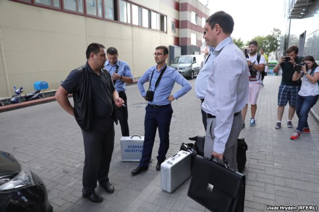 Сотрудники Следственного комитета с изъятой техникой возле офиса TUT.BY. Фото Владимира Гридина