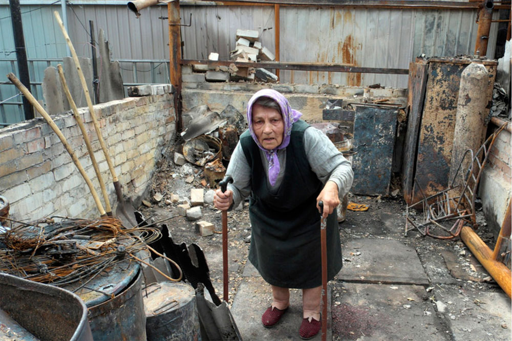 A resident of the Artema suburb of Sloviansk, Ukraine, in the rubble of what used to be her summer kitchen, in July 2014. Photo: UNHCR/Iva Zimova