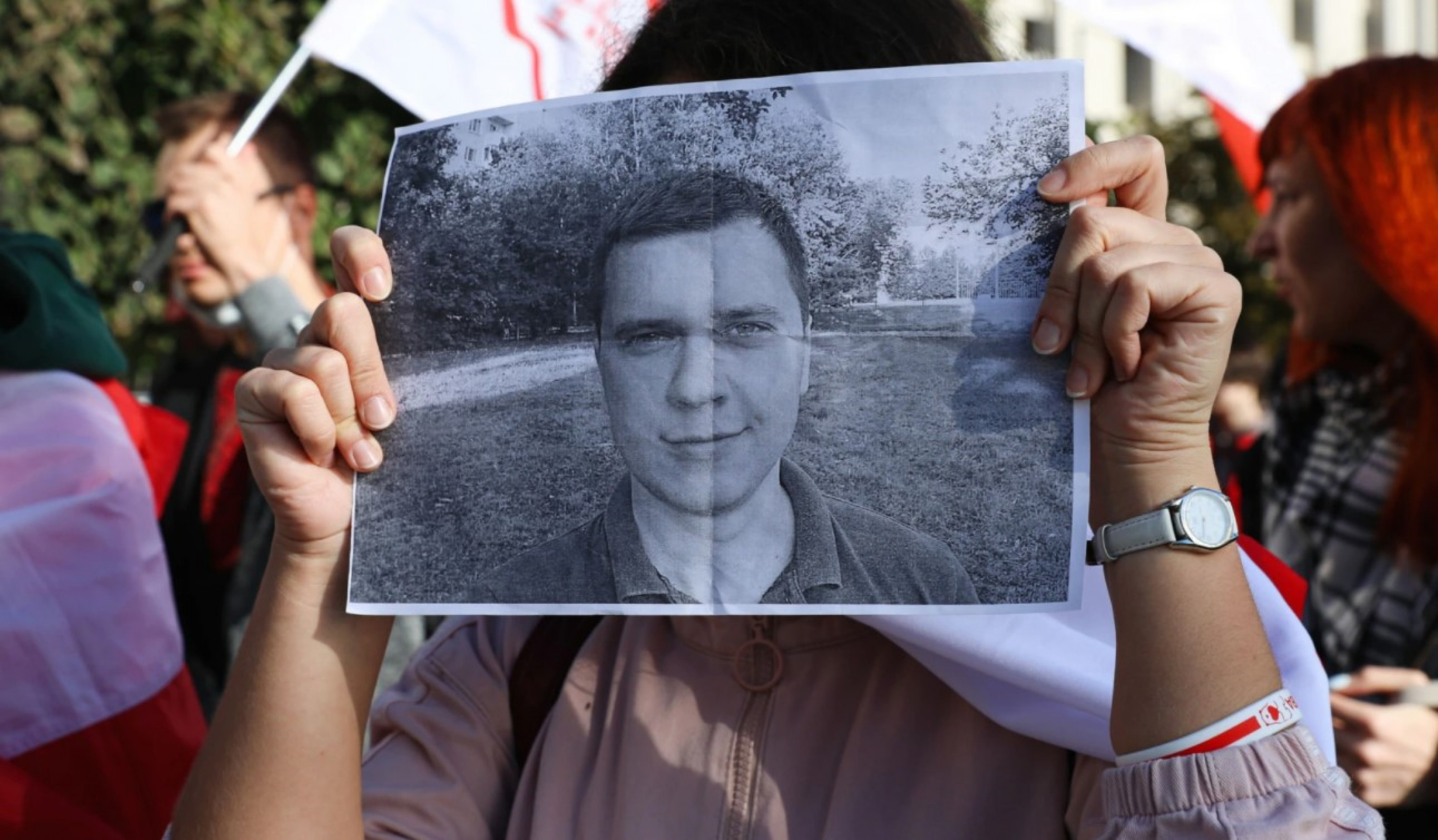 A protester holds Andrei Zeltser's photo.