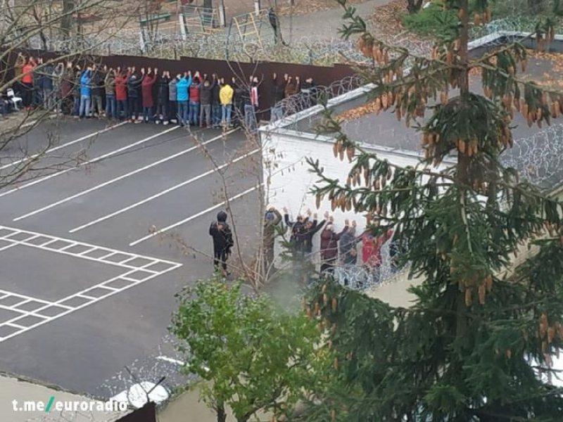 Detained protesters facing the fence in the Saviecki district police department of Minsk on November 8, 2020. They were forced to stand with their hands in the air for hours before being booked. Photo: tut.by