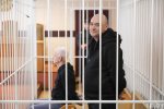 "Запертые в клетке и скованные наручниками борцы за права человека, — вот иллюстрация белорусского правосудия"